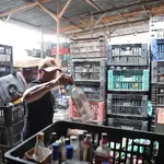 Agente da Polícia Civil durante ação em fábrica clandestina de bebidas alcóolicas | Foto: Divulgação/Agência SP