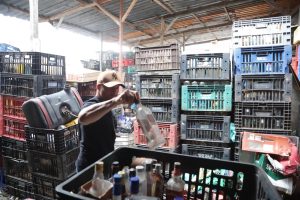 Agente da Polícia Civil durante ação em fábrica clandestina de bebidas alcóolicas | Foto: Divulgação/Agência SP