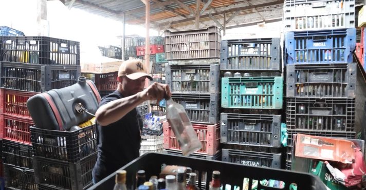 Agente da Polícia Civil durante ação em fábrica clandestina de bebidas alcóolicas | Foto: Divulgação/Agência SP