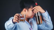 Homem segura bebida alcoólica, em alusão à nota do metanol
