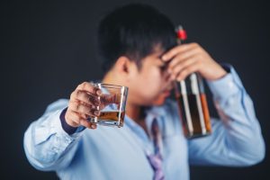 Homem segura bebida alcoólica, em alusão à nota do metanol