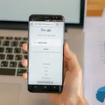 Homem segura celular com o site do Google aberto