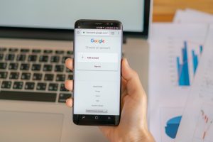 Homem segura celular com o site do Google aberto