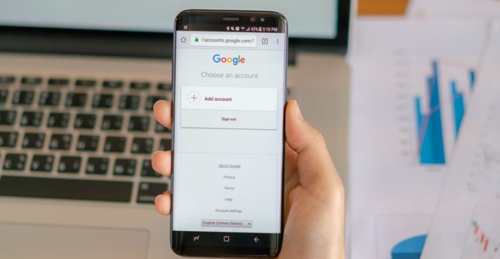 Homem segura celular com o site do Google aberto