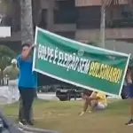 Manifestantes exibem faixa em frente ao condomínio do ex-presidente, no Rio de Janeiro | Foto: Reprodução/X
