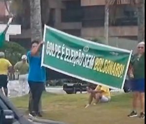 Manifestantes exibem faixa em frente ao condomínio do ex-presidente, no Rio de Janeiro | Foto: Reprodução/X