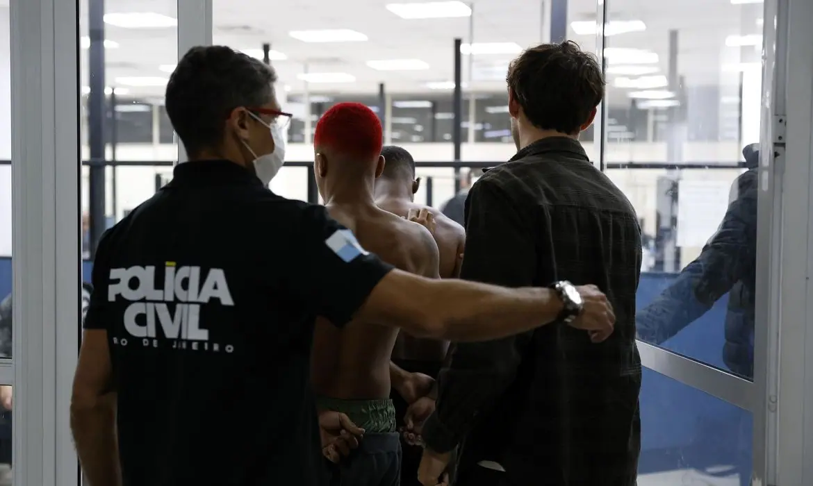 Agentes policiais encaminham membros do Comando Vermelho para a prisão | Foto: Fernando Frazão/Agência Brasil