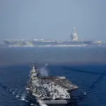 Em segundo plano, o USS Gerald R. Ford, o maior porta-aviões do mundo, que está em missão na América Latina | Foto: Reprodução/Twitter/X