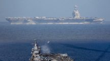 Em segundo plano, o USS Gerald R. Ford, o maior porta-aviões do mundo, que está em missão na América Latina | Foto: Reprodução/Twitter/X