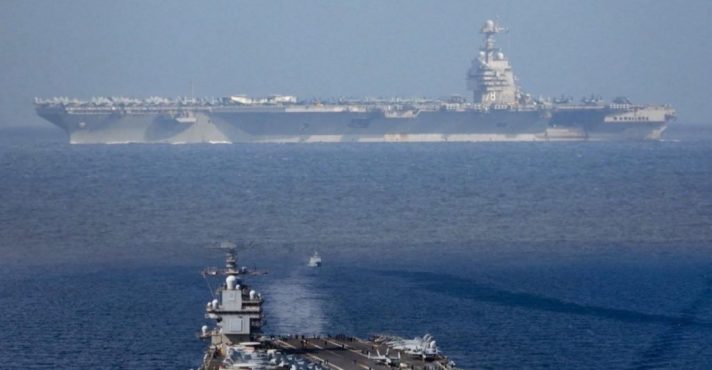 Em segundo plano, o USS Gerald R. Ford, o maior porta-aviões do mundo, que está em missão na América Latina | Foto: Reprodução/Twitter/X