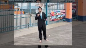 Zohran Mamdani em ato de campanha, vestindo terno e sem sapatos | Foto: Reprodução/Twitter/X