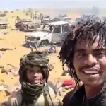 Soldados de grupo paramilitar posam para foto em meio a vítimas de massacre no Sudão | Foto: Reprodução/Twitter/X