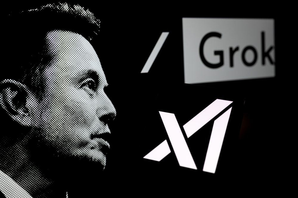 logotipo da Grok é exibido em um smartphone com Elon Musk ao fundo | Foto: Shutterstock
