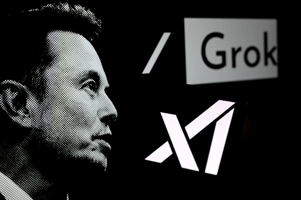 logotipo da Grok é exibido em um smartphone com Elon Musk ao fundo | Foto: Shutterstock
