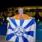 Lula posa em frente a bandeira da escola de samba Acadêmicos de Niterói | Foto: Acadêmicos de Niterói/Divulgação