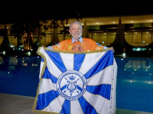 Lula posa em frente a bandeira da escola de samba Acadêmicos de Niterói | Foto: Acadêmicos de Niterói/Divulgação