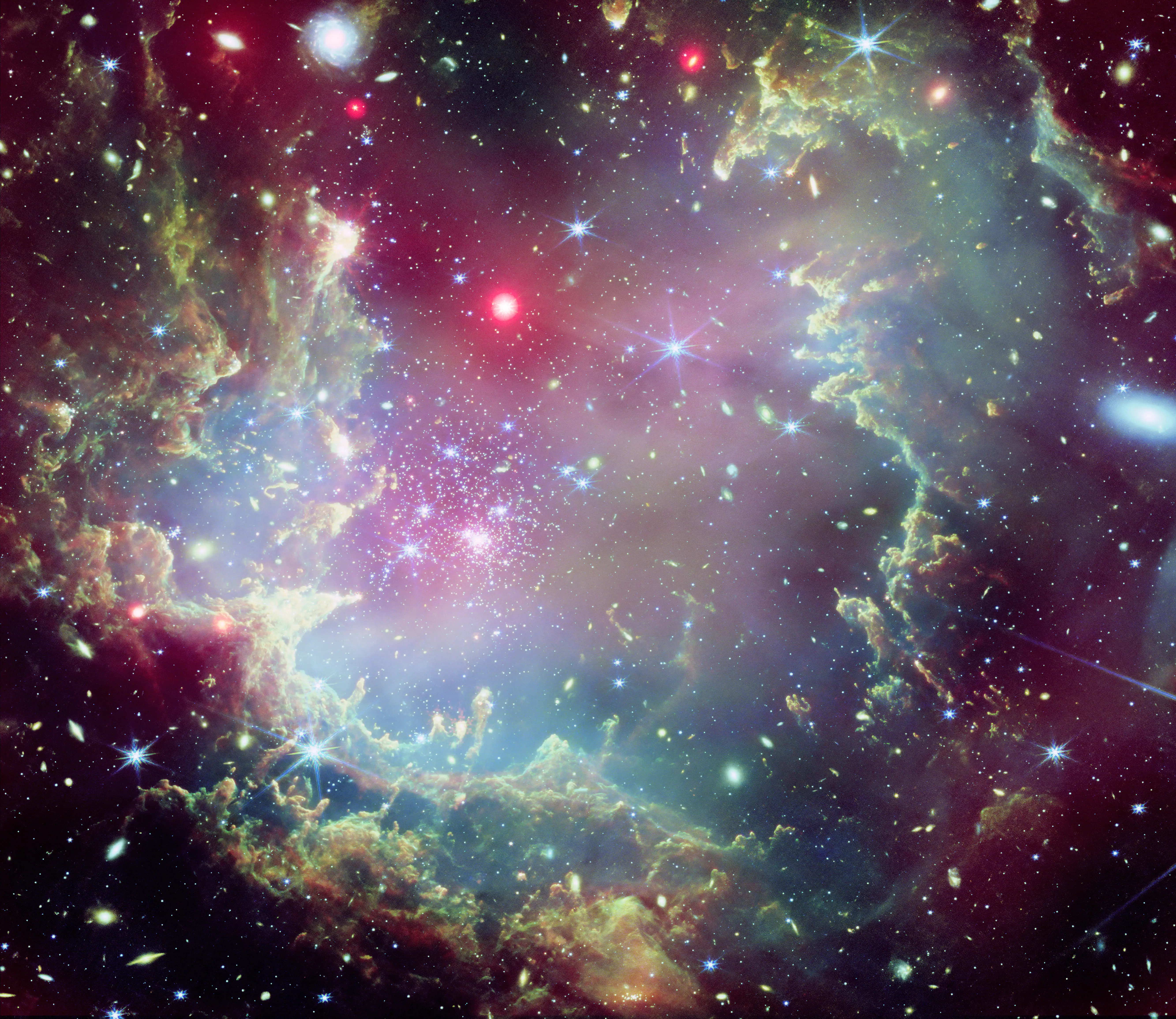 NGC 602 é um aglomerado estelar que fica nos arredores da Pequena Nuvem de Magalhães, uma das galáxias mais próximas da Via Láctea. Esta imagem combina raios-X do Observatório Chandra da Nasa e dados infravermelhos do Telescópio Espacial James Webb da Nasa | Foto: Divulgação/Nasa