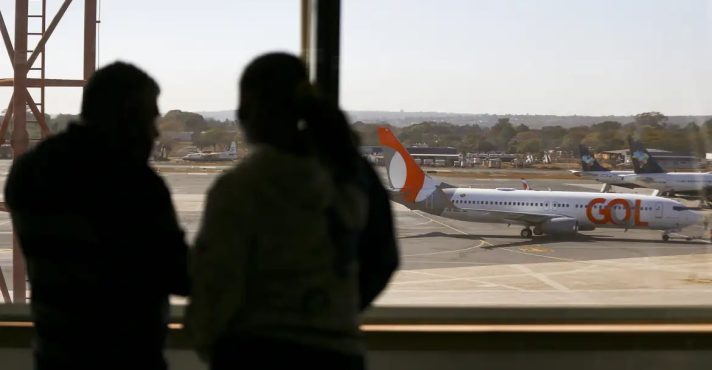 Passageiros observam avião da GOL em pista de aeroporto: risco de greve | Foto: Marcelo Camargo/Agência Brasil