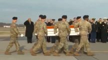 Trump (ao fundo) presta continência durante homenagem a soldados mortos na Síria | Foto: Reprodução/X