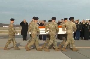 Trump (ao fundo) presta continência durante homenagem a soldados mortos na Síria | Foto: Reprodução/X