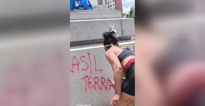 Mulher picha estátua durante manifestação de esquerda | Foto: FalaPanza/Reprodução