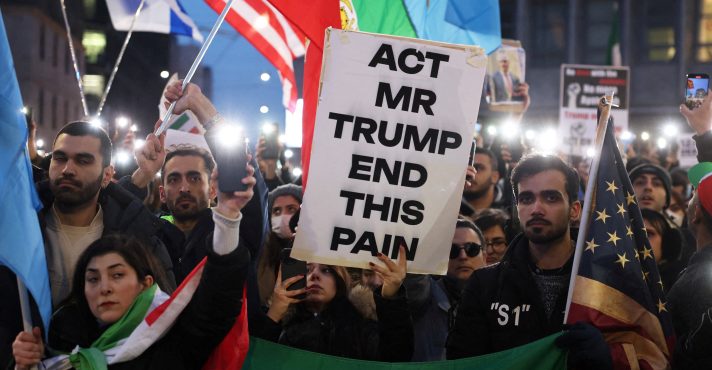 Pessoas acendem seus celulares em frente ao consulado dos EUA durante um protesto em apoio aos protestos nacionais no Irã, em Milão, Itália, 13 de janeiro de 2026 | Claudia Greco/Reuters