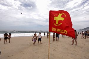 Uma bandeira de classificação de alto risco do Corpo de Bombeiros, colocada em Copacabana | Foto: Reprodução/Governo do RJ