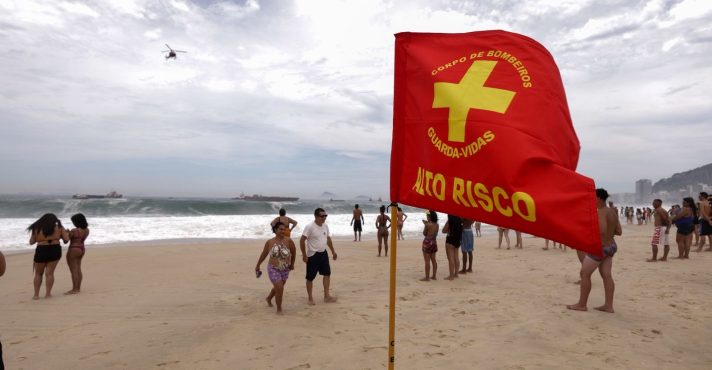 Uma bandeira de classificação de alto risco do Corpo de Bombeiros, colocada em Copacabana | Foto: Reprodução/Governo do RJ