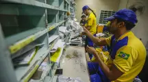 funcionários dos correios organizando correspondências