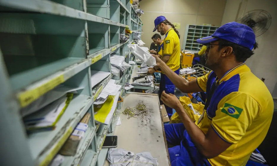 funcionários dos correios organizando correspondências