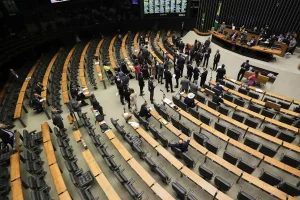 Câmara - Vista superior do plenário da Câmara dos Deputados com parlamentares reunidos durante sessão legislativa no Congresso Nacional.