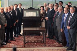 Autoridades dos Três Poderes reunidas em cerimônia solene no Supremo Tribunal Federal, ao redor de exemplar da Constituição Federal exposto.