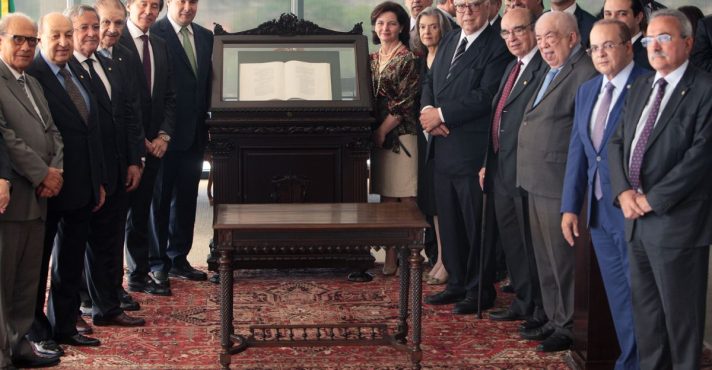 Autoridades dos Três Poderes reunidas em cerimônia solene no Supremo Tribunal Federal, ao redor de exemplar da Constituição Federal exposto.
