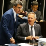 Parlamentares conversam durante sessão legislativa com documentos sobre gastos públicos sobre a mesa