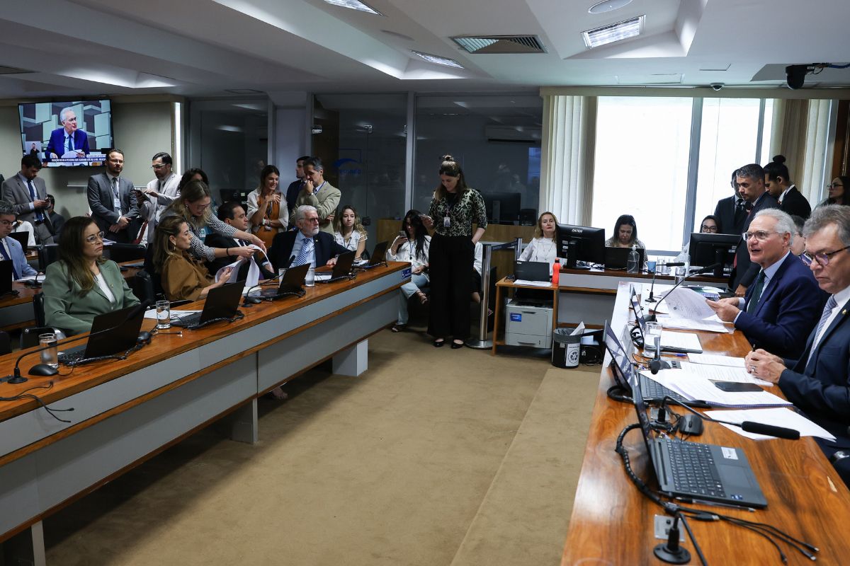 Audiência pública em comissão da Câmara dos Deputados sobre impostos no Brasil, com parlamentares, assessores e notebooks abertos durante o debate.