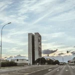 Congresso Nacional em Brasília com as torres do Poder Legislativo vistas de avenida urbana ao entardecer