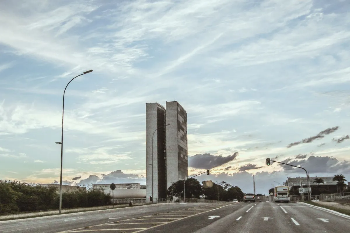 Congresso Nacional em Brasília com as torres do Poder Legislativo vistas de avenida urbana ao entardecer