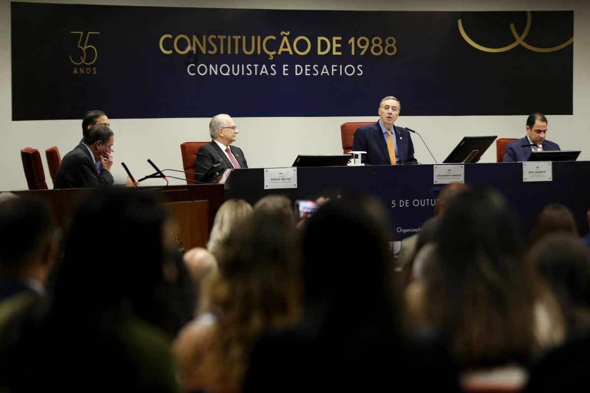 Autoridades participam de evento no Supremo Tribunal Federal sobre os 35 anos da Constituição de 1988, com painel institucional ao fundo.