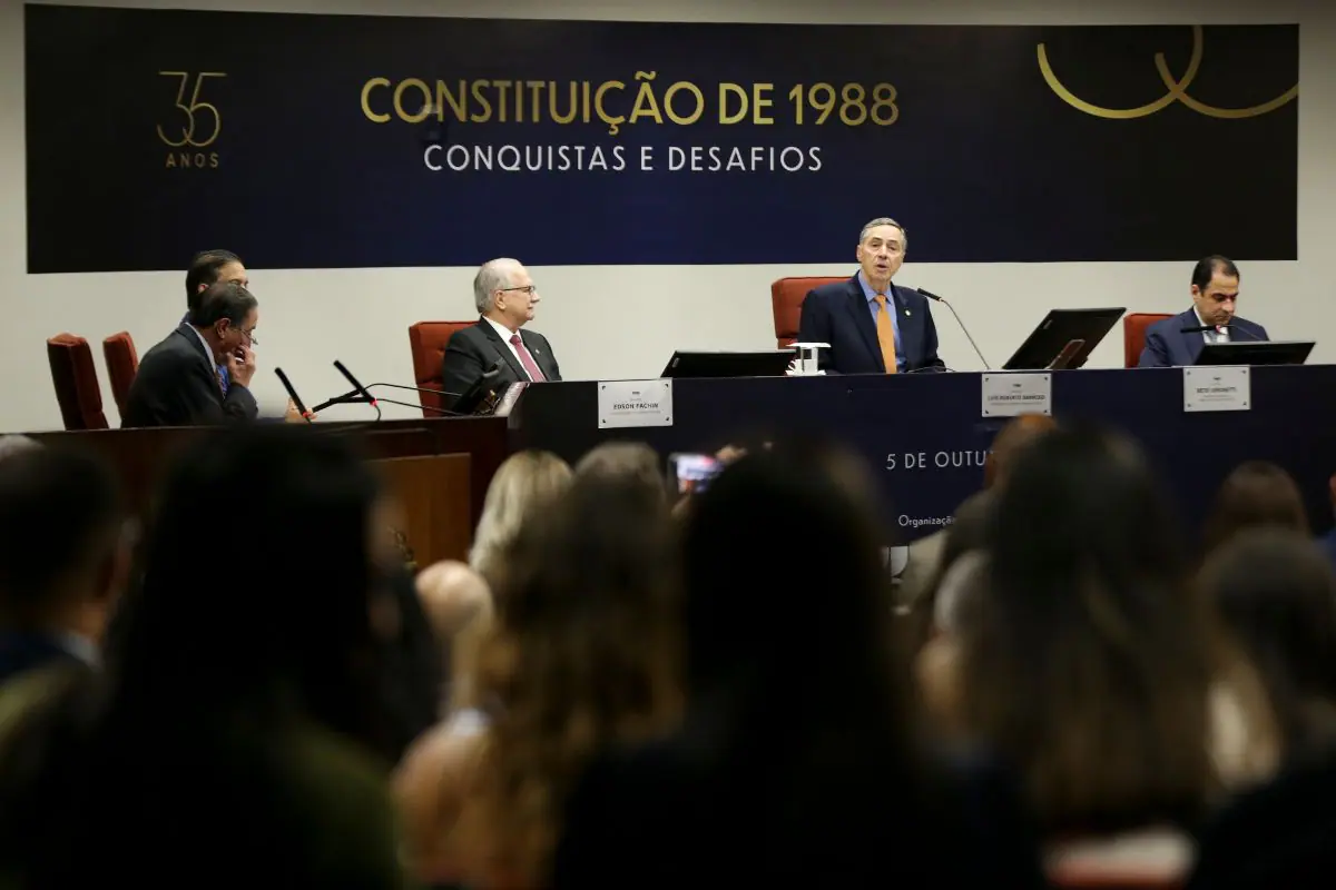 Autoridades participam de evento no Supremo Tribunal Federal sobre os 35 anos da Constituição de 1988, com painel institucional ao fundo.