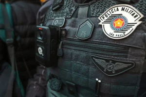Colete tático da Polícia Militar de São Paulo com câmera corporal acoplada e distintivos oficiais da corporação