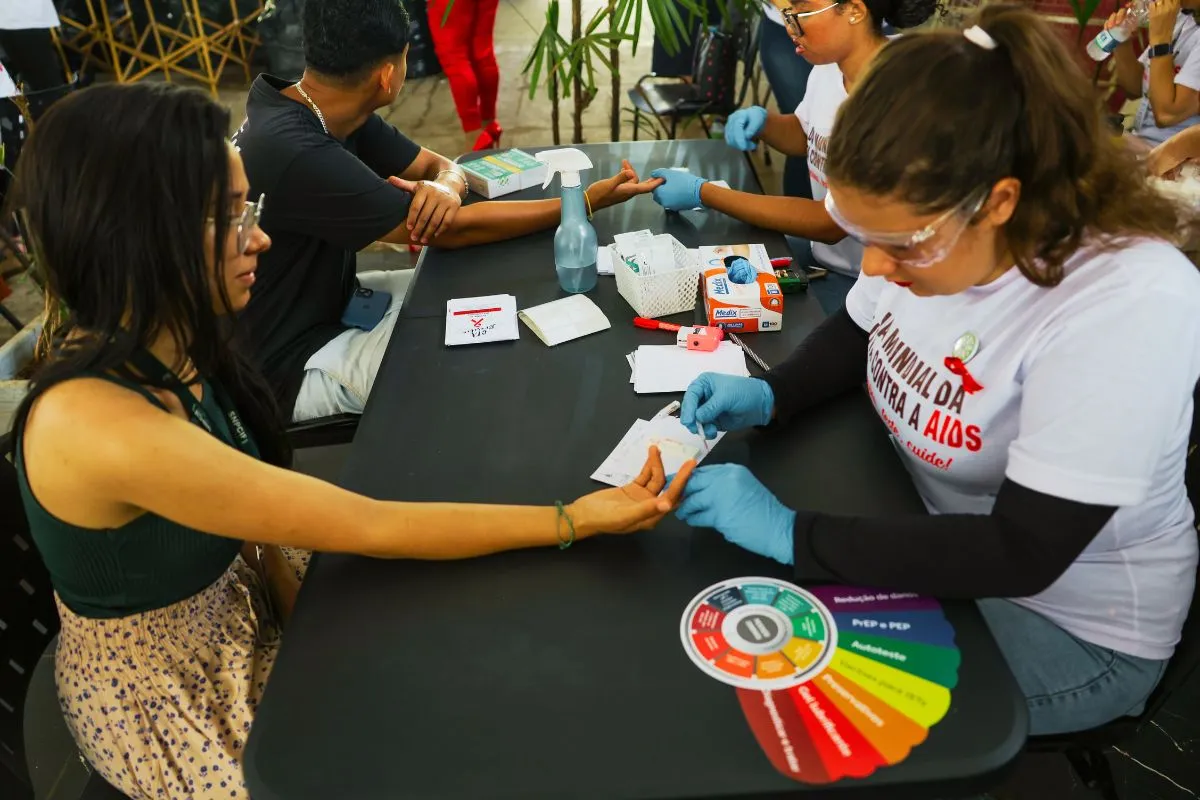 Profissionais de saúde realizando teste rápido de HIV em ação comunitária de prevenção e conscientização sobre AIDS