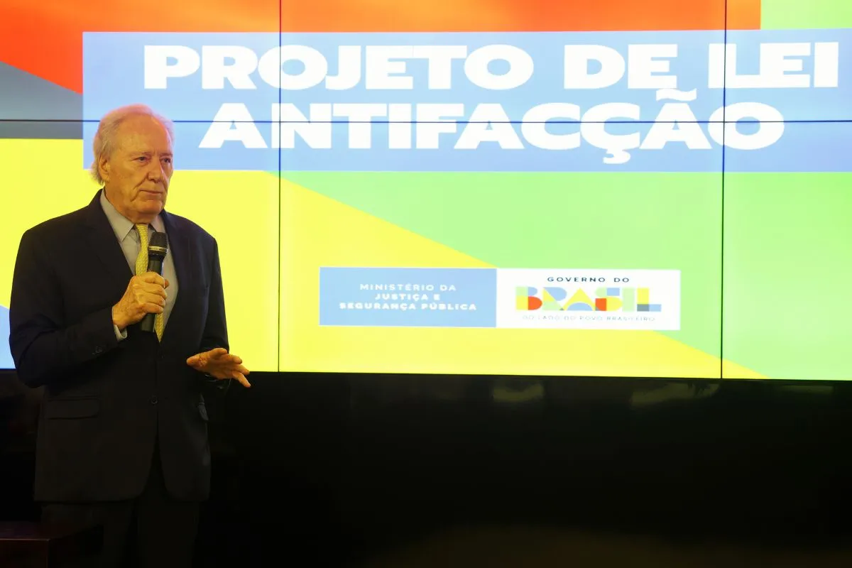 Autoridade segurando microfone durante apresentação do projeto de lei antifacção em painel oficial do governo brasileiro