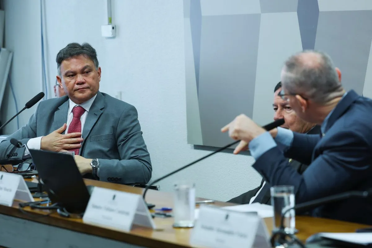 Autoridades participam de audiência em comissão parlamentar, com microfones e notebooks durante debate institucional