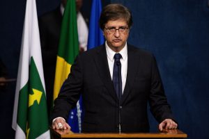 Autoridade brasileira discursando em tribuna durante pronunciamento oficial, com bandeiras ao fundo.