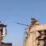 Soldados paquistaneses arrancando a bandeira dos talibãs em um posto de fronteira no Afeganistão e hasteando a bandeira do Paquistão