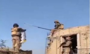 Soldados paquistaneses arrancando a bandeira dos talibãs em um posto de fronteira no Afeganistão e hasteando a bandeira do Paquistão