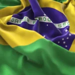 Bandeira do Brasil em tecido ondulado com cores verde, amarelo e azul e a frase Ordem e Progresso em destaque