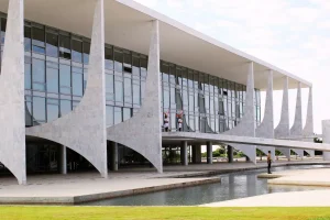 Fachada do Palácio do Planalto em Brasília, sede do Poder Executivo Federal, com espelho d’água e arquitetura moderna.