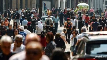 Grande fluxo de pessoas caminhando em rua movimentada de cidade do Brasil