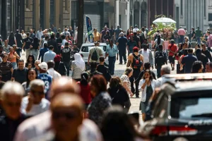 Grande fluxo de pessoas caminhando em rua movimentada de cidade do Brasil